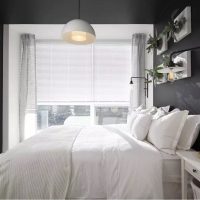Bílá postel v místnosti s šedými stěnami