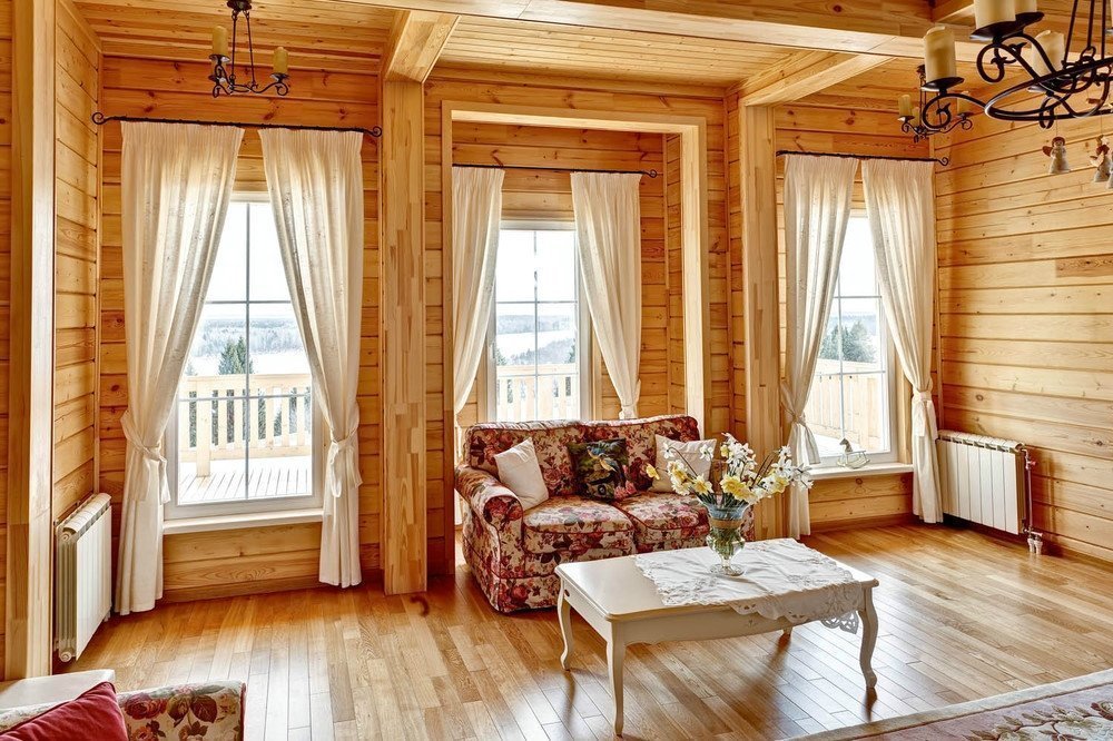 Trei ferestre în sufrageria unei case din lemn