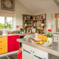Dzeltenas un sarkanas krāsas privātmājas virtuvē