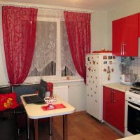 Rode gordijnen in het interieur van een kleine keuken