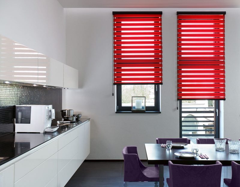 Kuhinjski interijer s crvenim zavjesama na prozorima