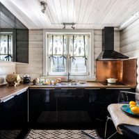 Bucătărie cu mobilier negru într-o casă din lemn