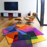 Ryškus kilimas iš kvadratinių įvairių spalvų audinių gabalų