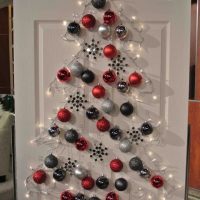 Pokok natal yang diperbuat daripada belon berwarna-warni di atas pintu putih