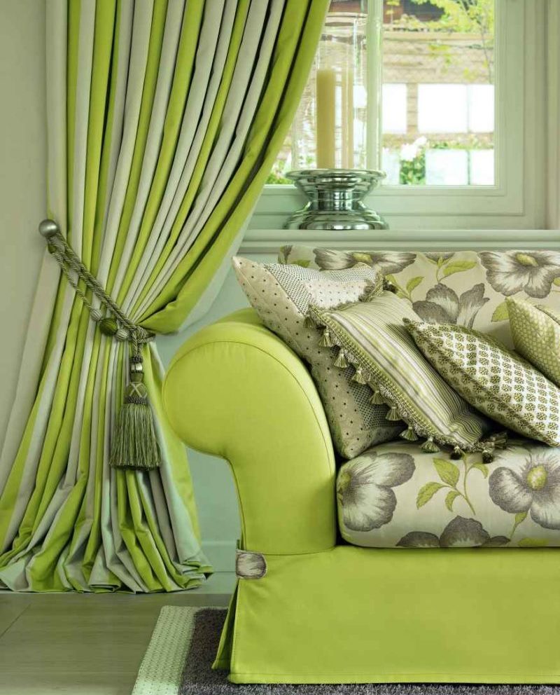 Dīvāns viesistabā ar gaiši zaļu apdari