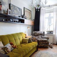 Canapea cu tapițerie de măsline în hol cu ​​perdele negre