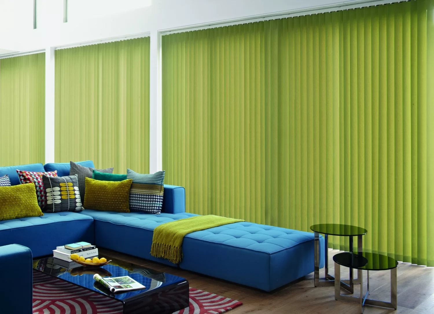 Modrá pohovka v obývacím pokoji se zelenými závěsy