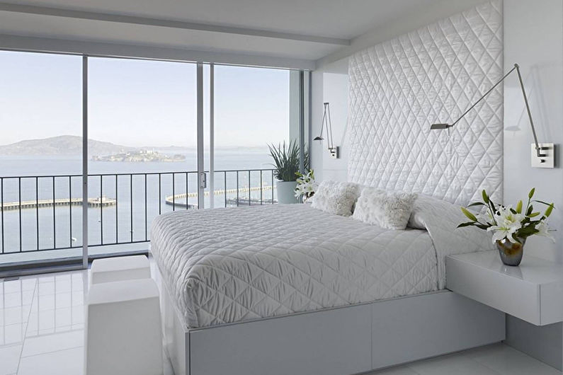 Katil putih di dalam bilik tidur dengan tingkap panorama