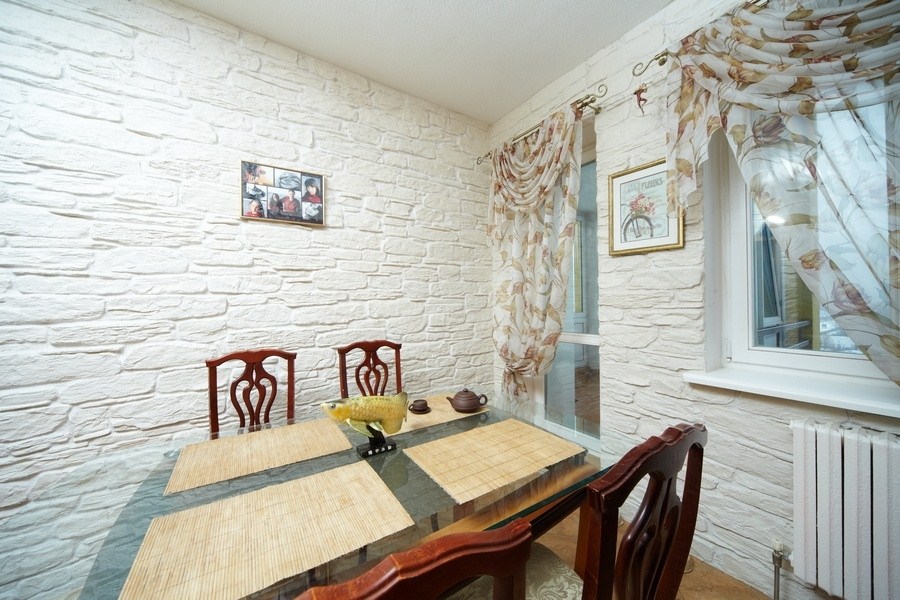 Virtuves interjers ar baltu akmeni uz sienām