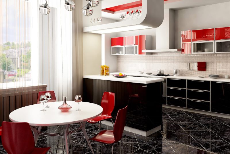 Zwart-witte keuken met rode stoelen.
