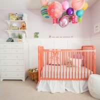Kleurrijke ballonnen boven een babywieg