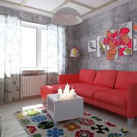 Sarkans dīvāns istabā ar pelēkām sienām
