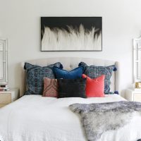 Įvairiaspalvės pagalvės ant lovos miegamajame