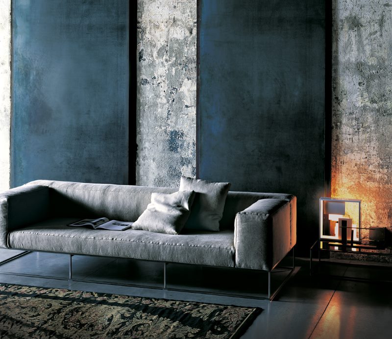 Sofa kelabu berhampiran dinding grafit di ruang tamu