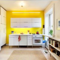 Gele muur in een witte keuken