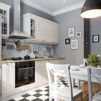 Juodos ir baltos spalvos languotos virtuvės grindys su pilkomis sienomis.