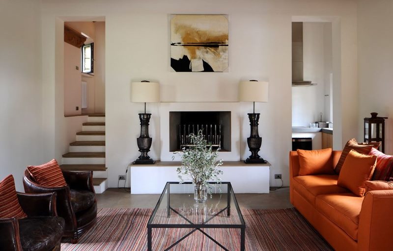 Oranžinė sofa svetainės interjere su židiniu