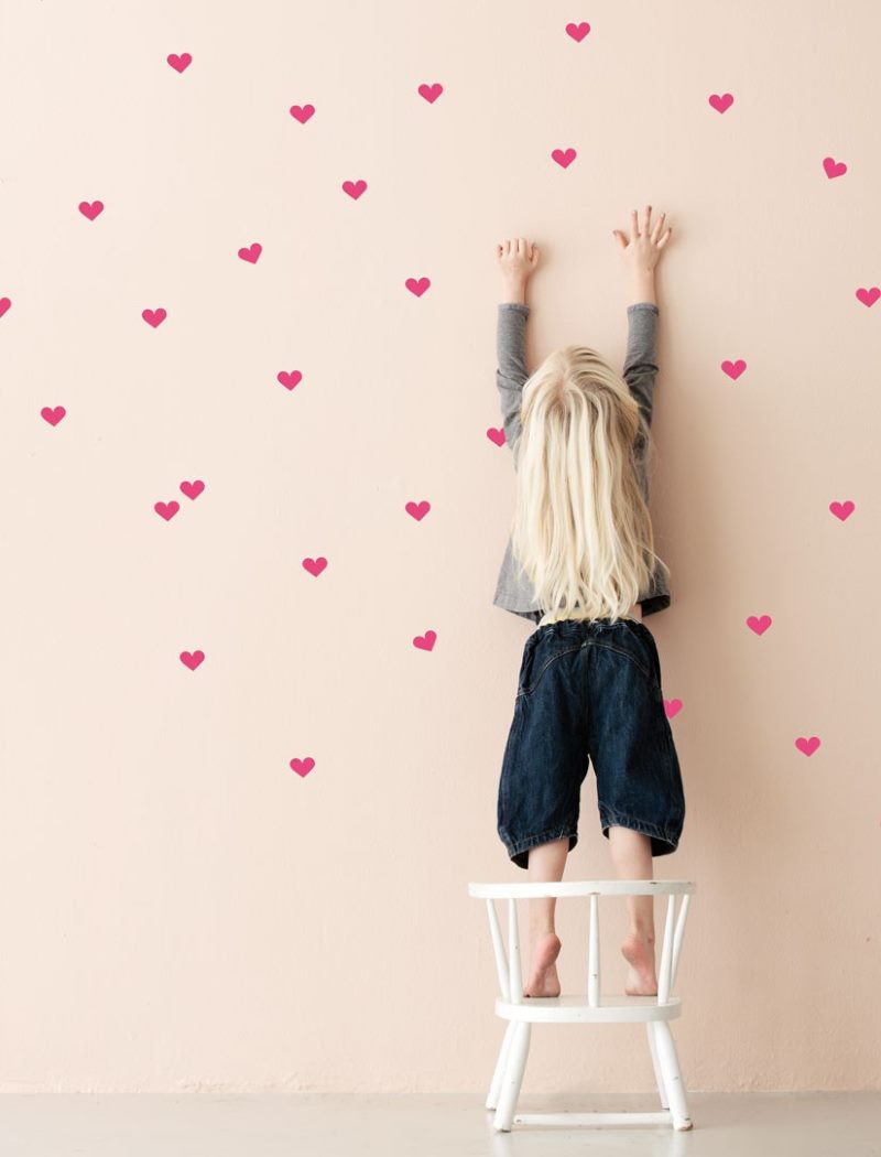 Decorarea unui perete roz cu inimi roșii