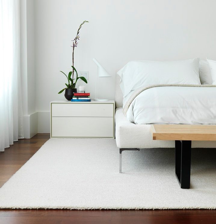 Minimālisma balts paklājs guļamistabas grīdā