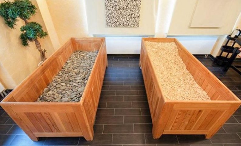 Houten kisten met kiezelstenen en zaagsel in een Japanse sauna