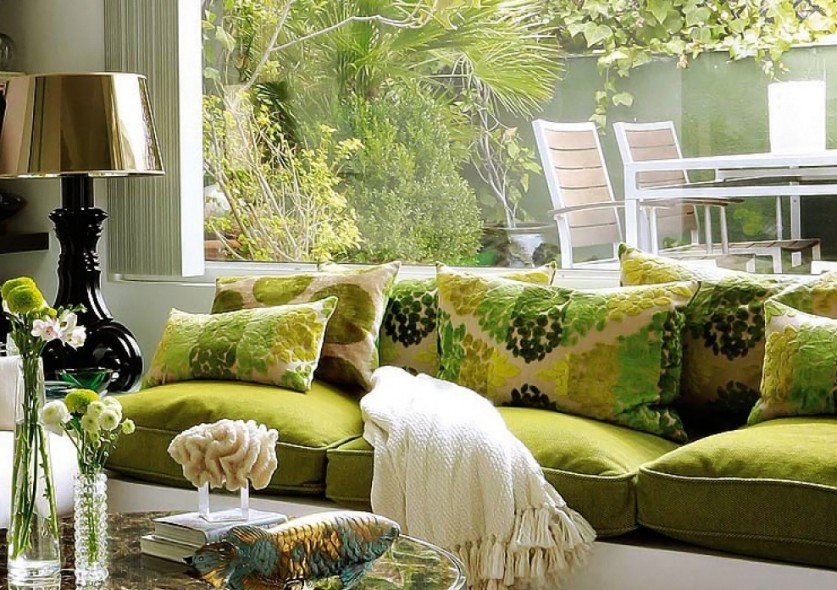 Green sofa in front of the living room window in a private house
