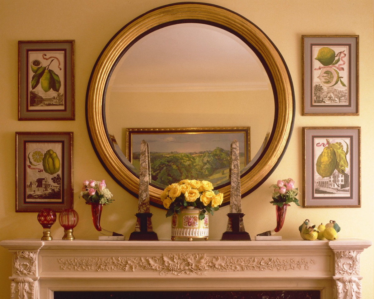 Ronde spiegel in een gouden frame boven de open haard