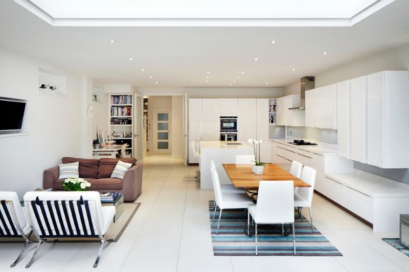 Plašas virtuves-viesistabas dizains ar baltu komplektu