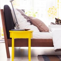 Scaun galben în fața patului din dormitor