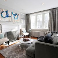 Interiér šedého obývacího pokoje s krbem