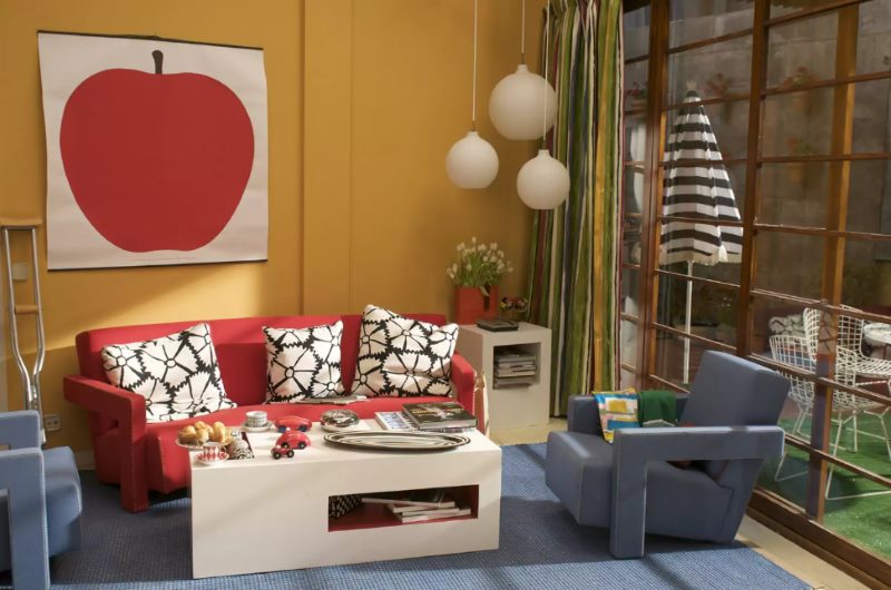 Glezna ar lielu ābolu uz viesistabas oranžās sienas