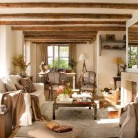 Světlý obývací pokoj s dřevěnými trámovými stropy.