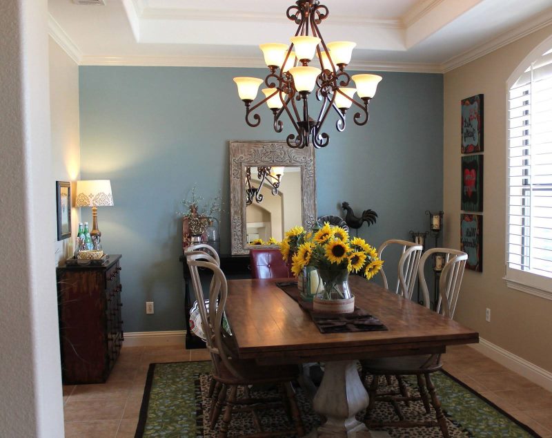 Lustr s kovanými železnými prvky nad jídelním stolem v obývacím pokoji soukromého domu.