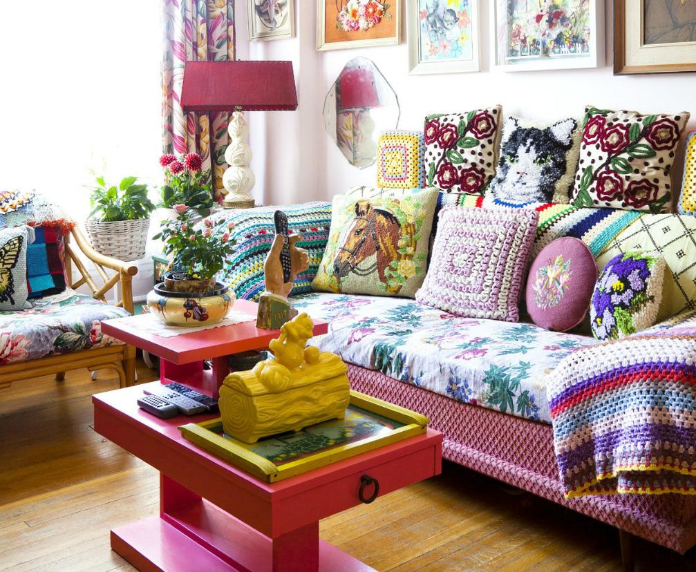Bantal pelbagai warna di atas sofa dengan selimut berwarna-warni