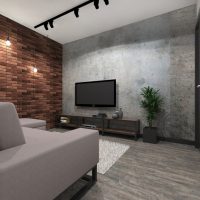 Melns tv viesistabā ar ķieģeļu sienu