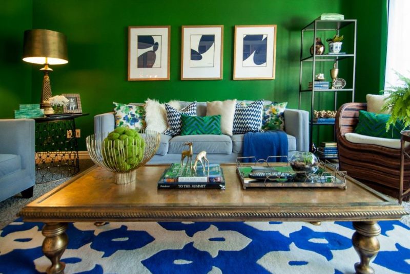 Modulární obrazy na tmavě zelené stěně obývacího pokoje
