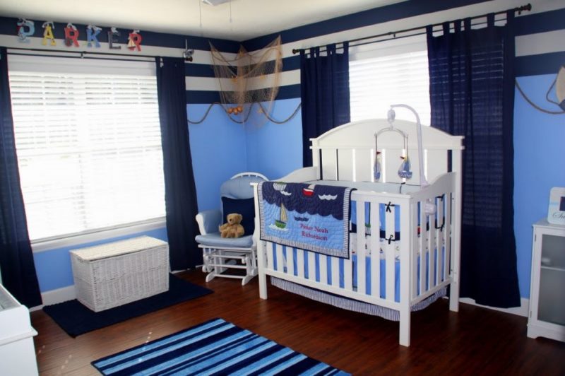 Witte babywieg in een kamer met blauwe gordijnen