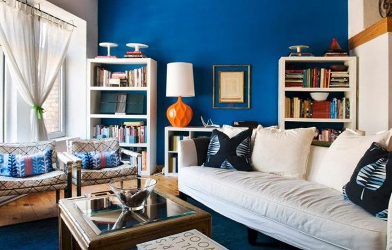 Bílá pohovka v obývacím pokoji s modrou podlahou a stěnou