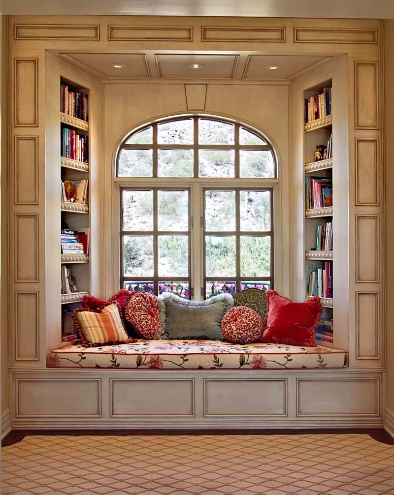 Mazs dīvāns grāmatu lasīšanai loga atvērumā