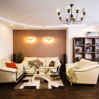 Dzīvojamās istabas dizains ar trim dīvāniem