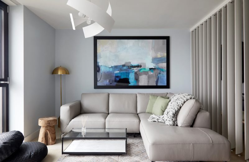 Abstrakce nad šedou pohovkou v malém obývacím pokoji