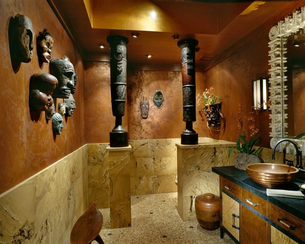 Masky afrických idolů na stěně koupelny